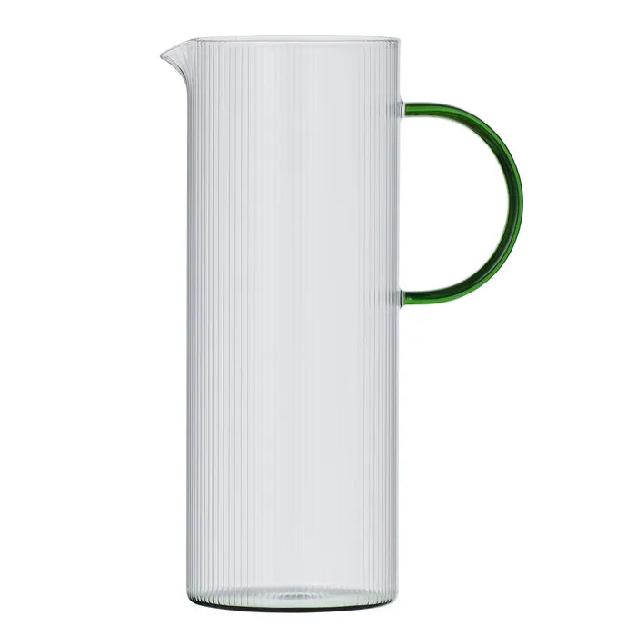 Ribbed clear glass jug with a green handle and base on awhite background