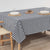 Table with a navy and white checkered tablecloth, wooden chairs, and minimal decor.