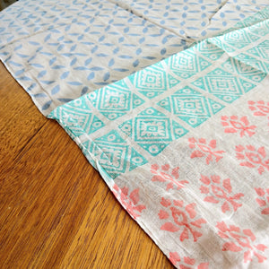 Three patterned cloths on a wooden surface