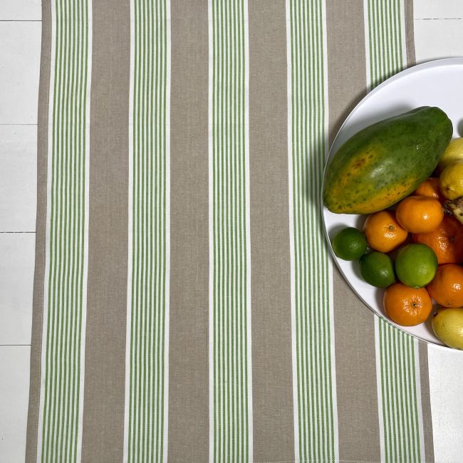 Fruit on a white plate on a striped teatowel