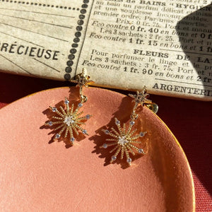 North star Earrings-Gold and cubic Zircoinia-Star shape-on a dish with newspaper