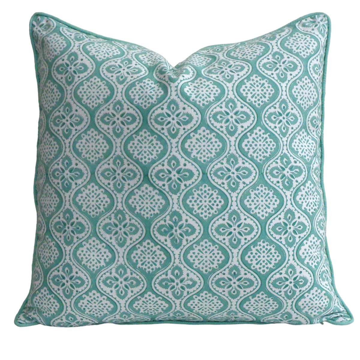 Green and white patterned pillow on a white background