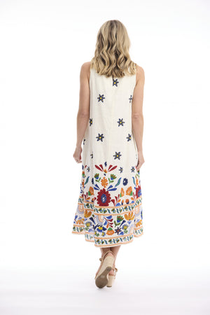 A woman viewed from behind wearing a sleeveless midi dress with a cream base and colorful floral embroidery concentrated along the hem and scattered across the back. She is walking against a seamless white studio background.