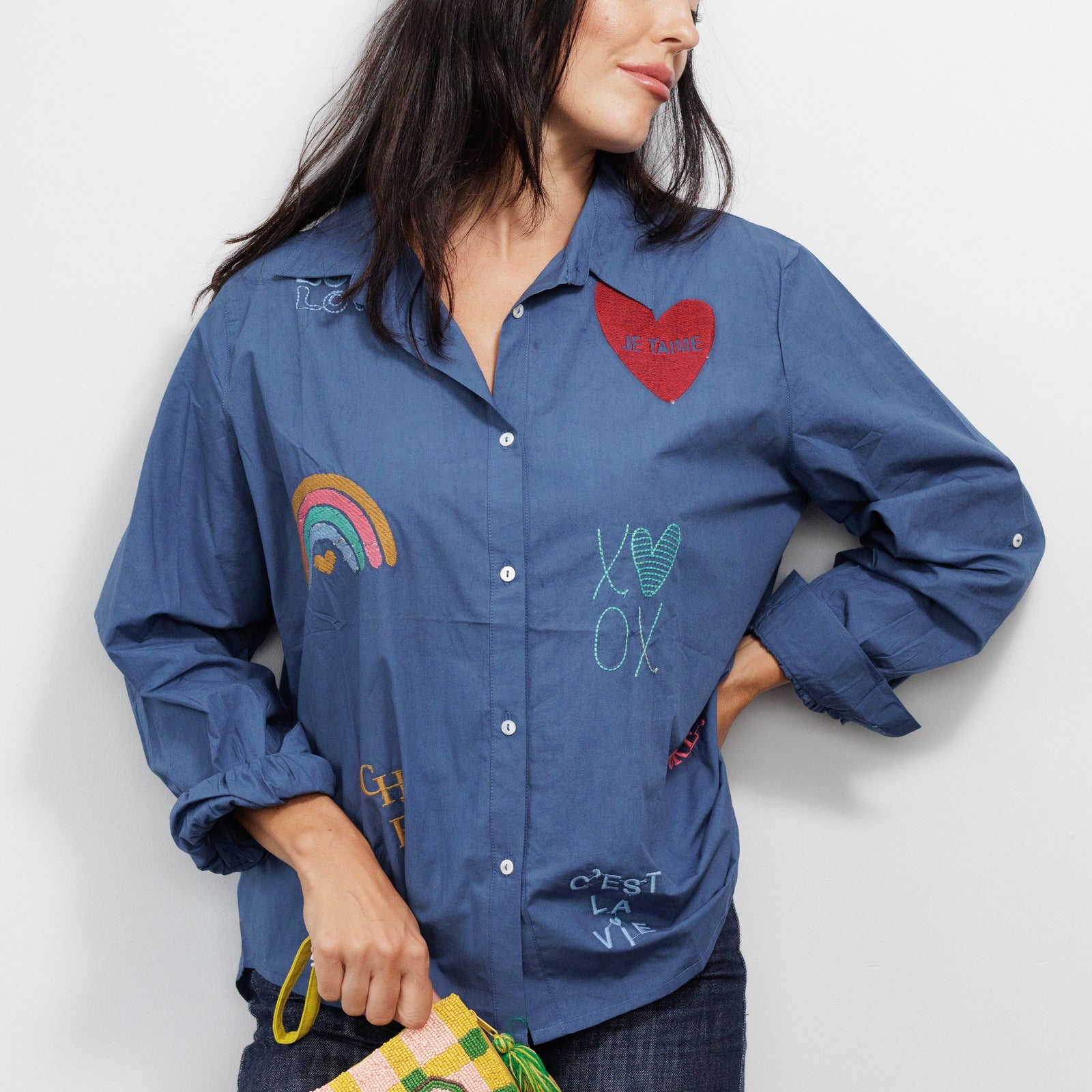 Woman wearing a blue shirt with colorful designs.