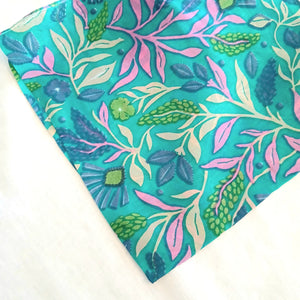 Floral patterned scarf with blue, green, and pink colors on a white background