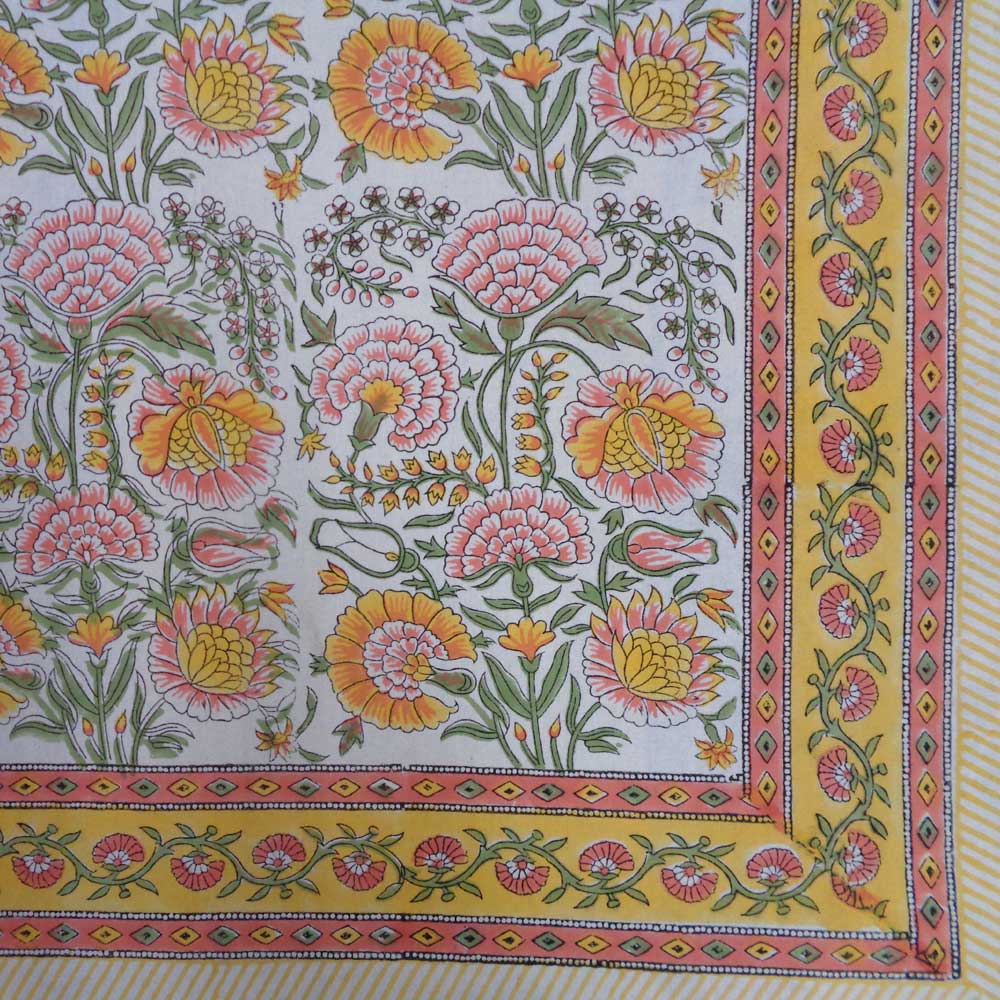 Colorful floral patterned tablecloth with a yellow border on a white background
